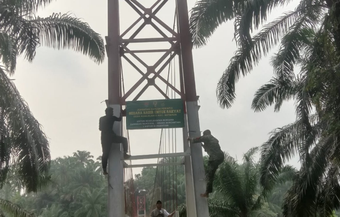 Babinsa Ketahun Pasang Spanduk Imbauan Keselamatan di Jembatan Perintis Garuda